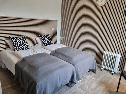 a bedroom with two beds and a wall at Vestbjerg Apartments in Vestbjerg