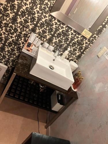 a bathroom with a white sink and a mirror at X Hotel - Adult Only- in Sayama