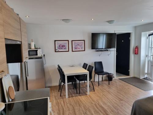 a kitchen and living room with a table and chairs at Vestbjerg Apartments in Vestbjerg