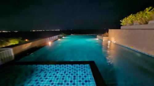 a swimming pool at night with the lights on at The Blu X Seaview F6 R156 in Ban Bang Saen (1)