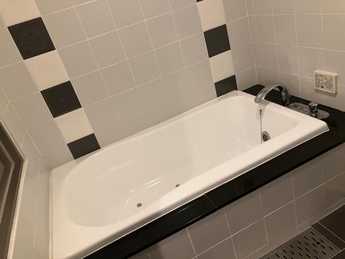 a white bath tub with a faucet in a bathroom at X Hotel - Adult Only- in Sayama