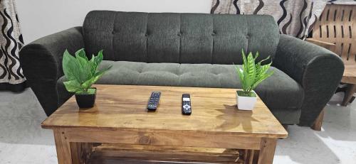 - un canapé noir avec deux télécommandes sur une table basse dans l'établissement OYO Vensa Homestay, à Purî