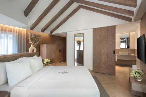 1 dormitorio con 1 cama blanca grande y TV en ZANA - A Luxury Escape, Dhikuli, Jim Corbett en Garjia