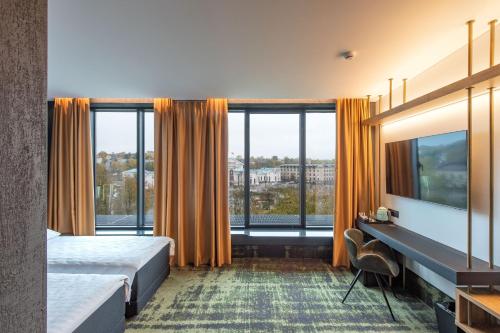 a hotel room with a bed and a large window at Hotel Panorama in Vilnius