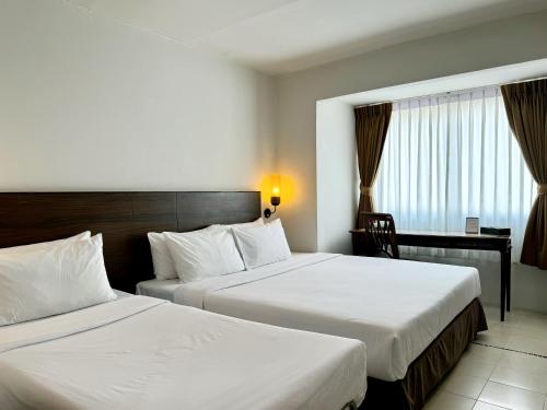 um quarto de hotel com duas camas e uma secretária em Pas Cher Hotel de Bangkok em Banguecoque