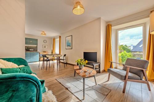ein Wohnzimmer mit einem Sofa und einem Tisch in der Unterkunft Kelenn - Maison avec jardin et terrasse in Plougastel-Daoulas