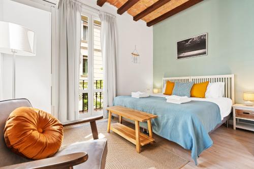 a bedroom with a large bed and a table at Lodging Apartments Beach Studio 22 in Barcelona