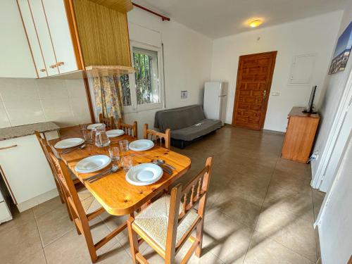 a dining table and chairs in a room with a kitchen at Bungalows Pescador in Segur de Calafell