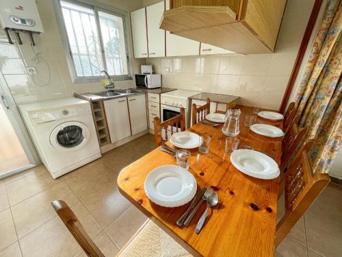 una cocina con una mesa de madera con platos. en Bungalows Pescador, en Segur de Calafell