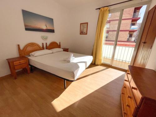 1 dormitorio con cama y ventana grande en Bungalows Pescador, en Segur de Calafell