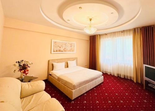 een hotelkamer met een bed en een bank bij Luxury Apartment in New Building in Chişinău