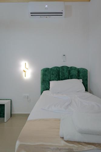 a bedroom with a large bed with a green headboard at Lago Calmo Villa in Ksamil