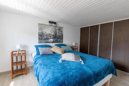 une chambre avec un lit avec une couverture bleue dans l'établissement Cocon à deux minutes de la mer., à Propriano