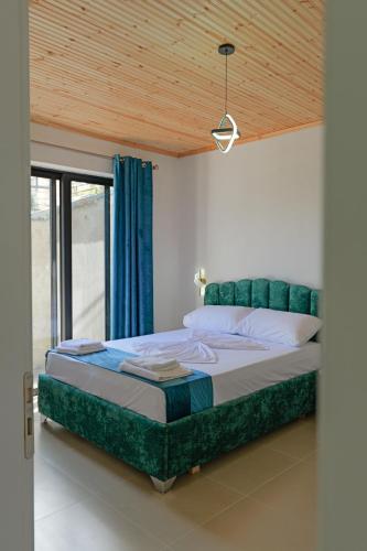 a bedroom with a large bed with a blue curtain at Lago Calmo Villa in Ksamil