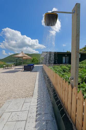 a water fountain in front of a wooden fence at Lago Calmo Villa in Ksamil