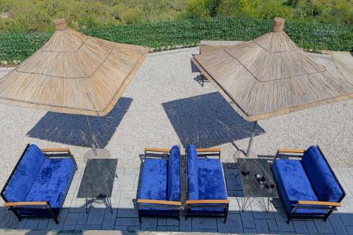 a group of blue chairs and umbrellas on a patio at Lago Calmo Villa in Ksamil