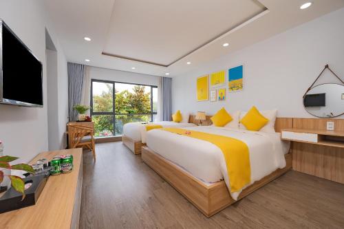 a hotel room with two beds and a flat screen tv at LASANTA Villa in Hoi An