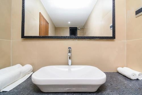 a white sink in a bathroom with a mirror at Okean De Goa Vagator in Vagator