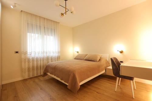 a bedroom with a bed and a desk and a window at Grandstay Portside in Durrës