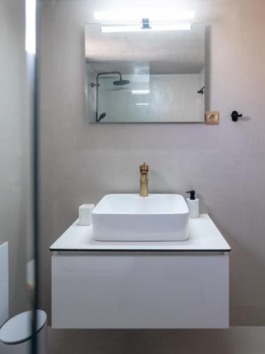 a bathroom with a white sink and a mirror at Loft 038 City Center in Heraklio