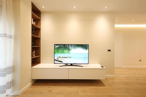 a living room with a television on a white cabinet at Grandstay Portside in Durrës