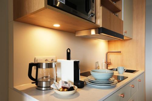 a kitchen counter with a coffee maker on a counter at Hood House Kassel - volldigitales Serviced Apartment in Kassel