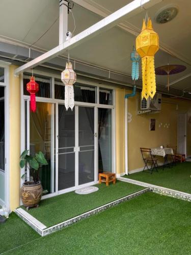 a porch with green grass and colorful lanterns at เอ็มยูโฮมรีสอร์ท in Ban Khlong Lam Hin