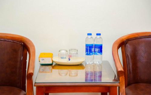 una mesa con botellas de agua y vasos. en lotus hotel 2 khách sạn bắc ninh en Bắc Ninh