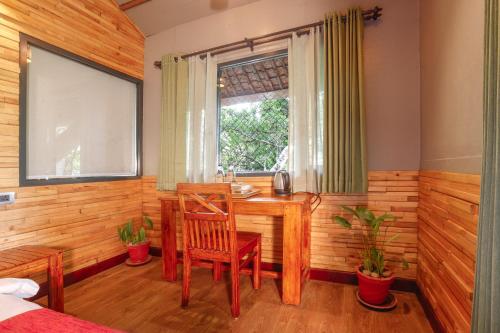 a room with a table and chairs and a window at Vythiri Resort in Vythiri