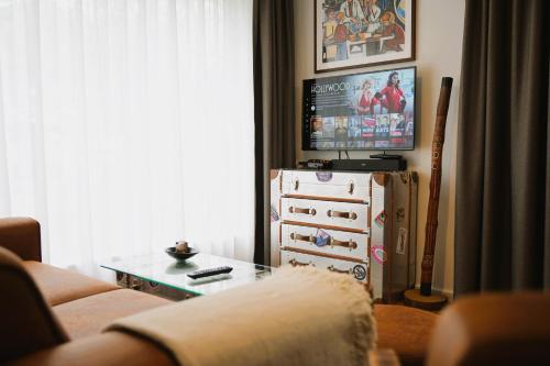 a living room with a couch and a tv at The Berlin Getaway / 80qm in Berlin's Historic Diplomatic Quarter in Berlin