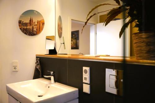 a bathroom with a sink and a mirror at The Berlin Getaway / 80qm in Berlin's Historic Diplomatic Quarter in Berlin