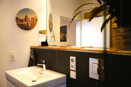 bagno con lavandino e specchio di The Berlin Getaway / 80qm in Berlin's Historic Diplomatic Quarter a Berlino