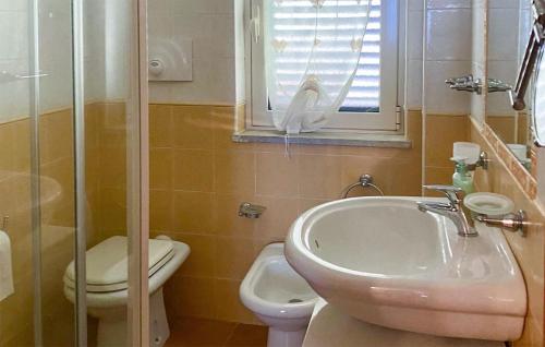 baño con lavabo y aseo y ventana en Nice Apartment In Furci Siculo With Kitchen, en Furci Siculo