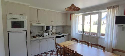 une cuisine avec une table en bois et une tableastery ... dans l'établissement Gîte montagne 1 à 25 places 