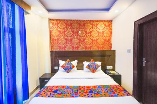 1 dormitorio con 1 cama con colcha colorida en FabHotel Green view palace, en Indirapuram