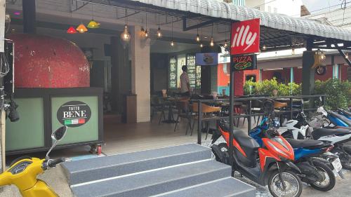 a row of scooters parked outside of a restaurant at PATONG BLUE HOTEL in Patong Beach