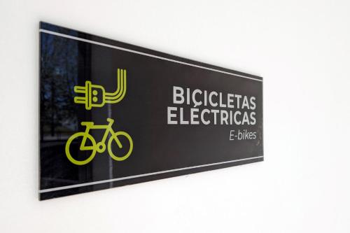 a sign on a wall with a bike on it at Duerming Villa de Arzúa in Arzúa