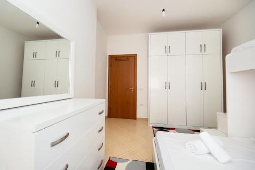 a bathroom with white cabinets and a mirror at Noa Apartments in Vlorë