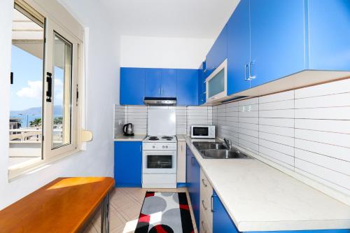a kitchen with blue cabinets and a sink at Noa Apartments in Vlorë