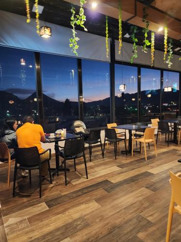 a restaurant with tables and chairs and a view of the city at Hotel Luna de Plata Aeropuerto in Quetzaltenango