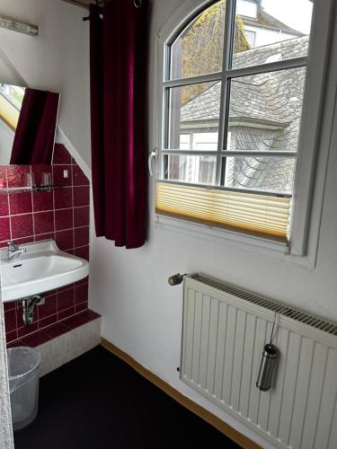 a bathroom with a sink and a window at City B&B Cochem in Cochem