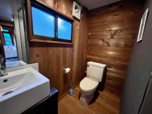 a bathroom with a white toilet and a sink at Hakuba Mountain Cabin in Hakuba