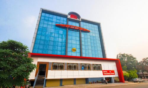 a tall glass building with a red circle on it at Itsy By Treebo - Yogeshwara Grand in Shamshabad