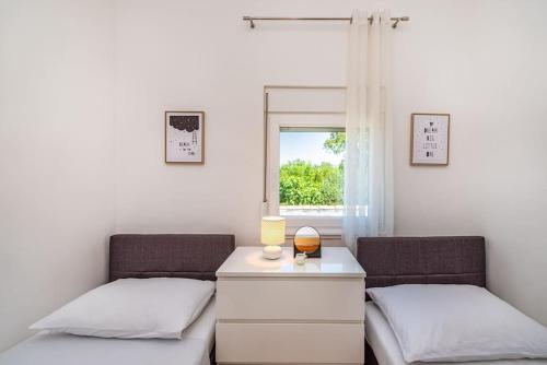 1 Schlafzimmer mit 2 Betten und einem Schreibtisch mit Fenster in der Unterkunft Villa Lena in Pridraga