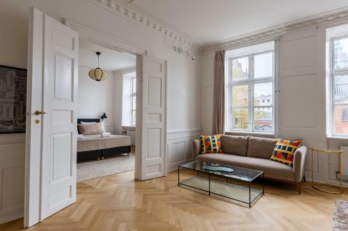 a living room with a couch and a table at Rare 4BR Apartment w Unique Details in CPH City in Copenhagen