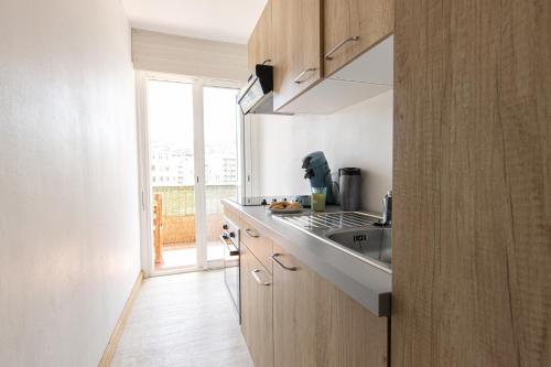 d'une cuisine avec un comptoir, un évier et une fenêtre. dans l'établissement le Valinco, à 2 pas de la mer, à Propriano