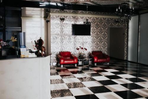 a living room with red chairs and a checkered floor at Amy in Oradea