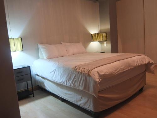 ein Schlafzimmer mit einem großen Bett mit zwei Lampen in der Unterkunft Korsmans Delights - Large House in Benoni