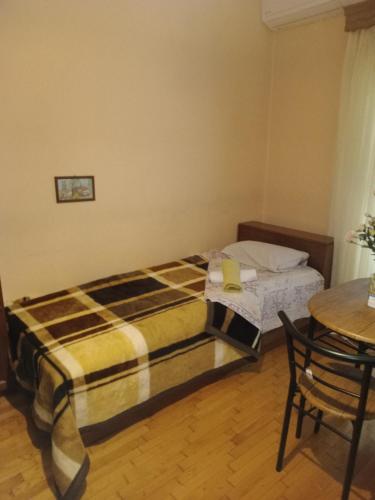 a bedroom with a bed and a table and chair at Christos ΙΙ in Asvestokhórion