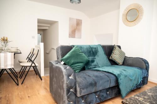 a leather couch with green pillows in a living room at Corporate-Friendly 2BR Apartment in Leeds, Near Kirkstall Shopping Centre in Leeds